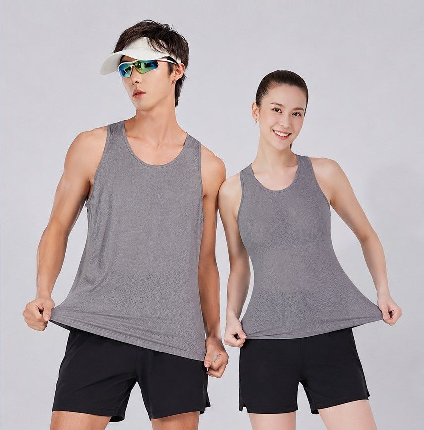 Man and woman wearing KINETRA grey running singlets outdoors