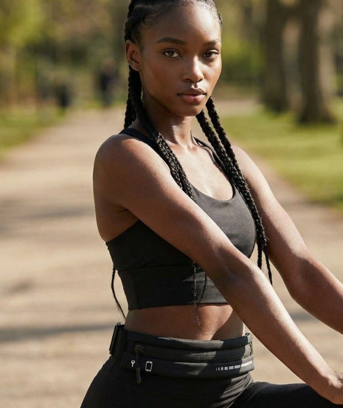 Runner wearing a KINETRA waist pouch while stretching outdoors